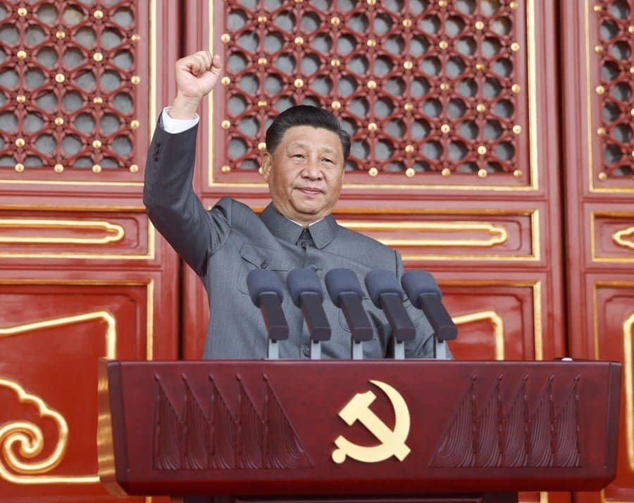 Xi Jinping acena em uma tribuna