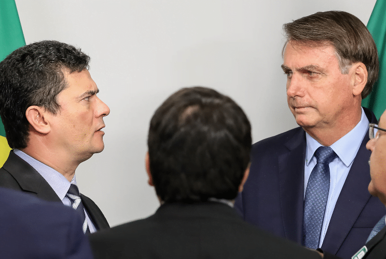 Sergio moro e Bolsonaro conversam diante de outros dois homens.