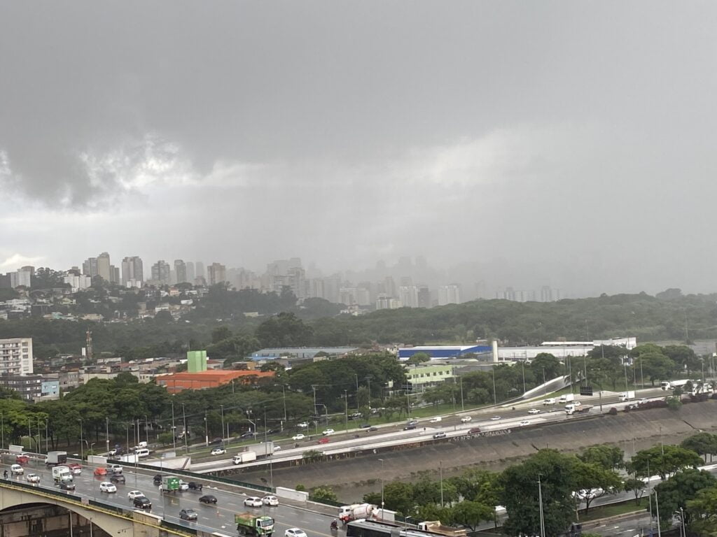 Foto mostra parte da cidade coberta por nuvem de chuva.