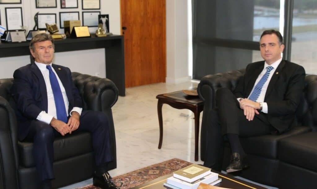 Luiz Fux, presidente do STF, sentado à esquerda e Rodrigo Pacheco, presidente do Senado, sentado à direita. Ambos estão em poltronas pretas.