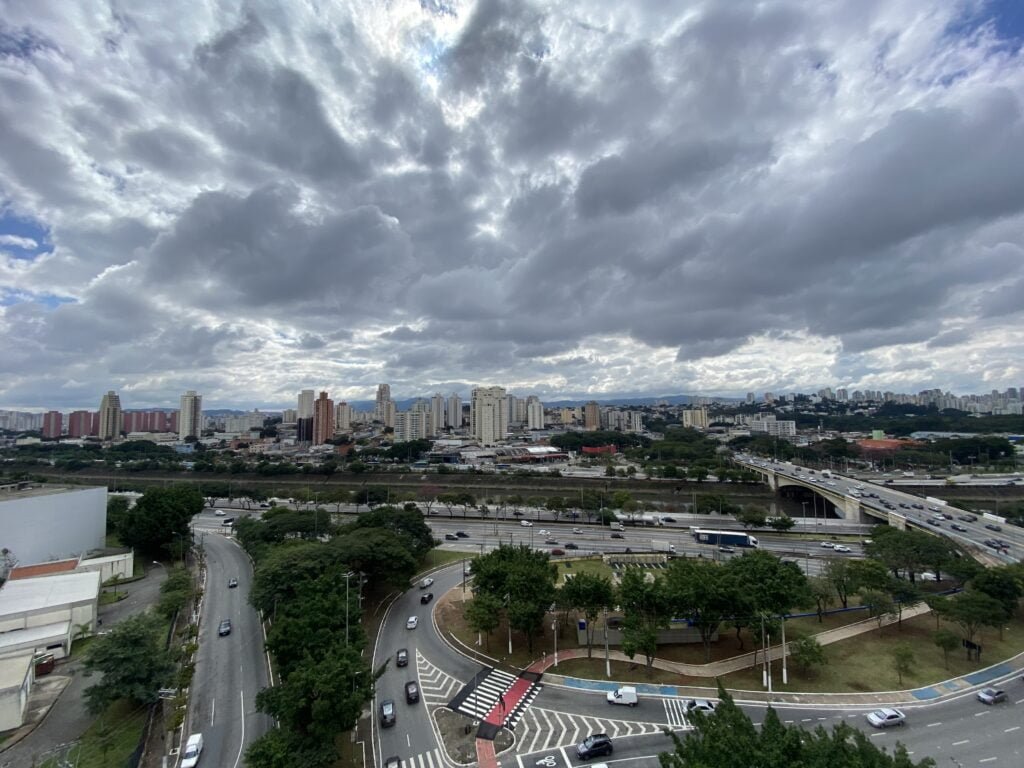 Céu de São Paulo encoberto por nuvens. Na parte de baixo da foto, carros transitam por vias de acesso e pela Marginal Tiete