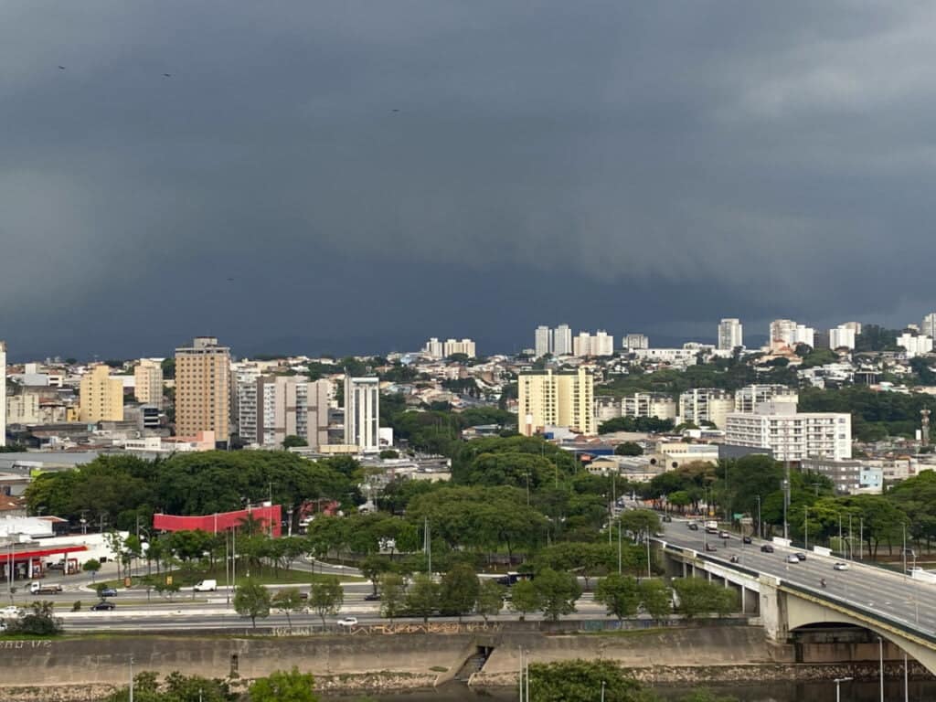 Imagem mostra nuvem carregada, escura, se aproximando de São Paulo. Na parte de baixo, parte da marginal tietê e prédios da zona norte.