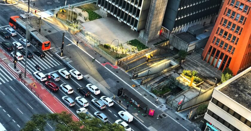 Imagem do alto mostra Avenida Paulista, com carros parados no semáforo.