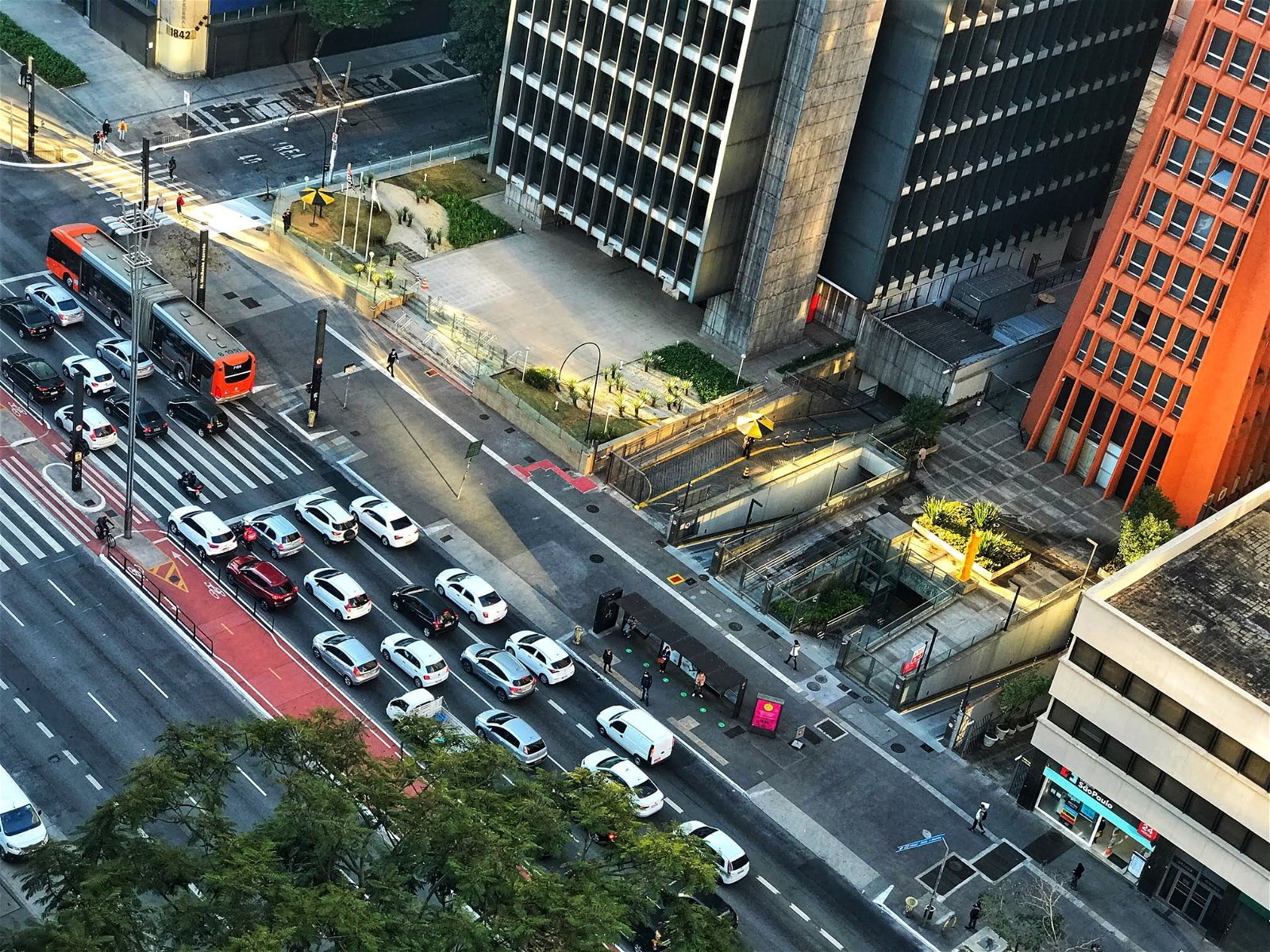 Imagem do alto mostra Avenida Paulista, com carros parados no semáforo.