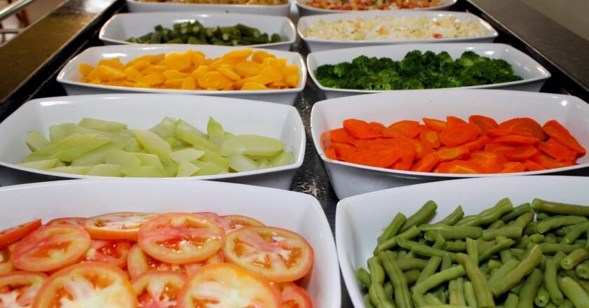 Pratos organizados lado a lado com legumes e saladas.