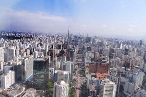 Imagem panorâmica de São Paulo mostra prédios e o céu com algumas nuvens.