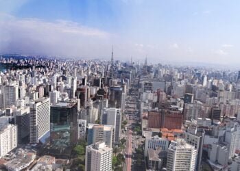 Imagem panorâmica de São Paulo mostra prédios e o céu com algumas nuvens.