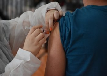 Agente de saúde aplica vacina no braço de morador, em Botucatu, interior de São Paulo.