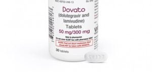 Comprimido de Dovato, medicamento usado contra o hiv, ao lado do fraco do remédio, em um fundo branco