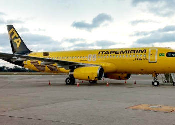 Aeronave da Itapemirim estacionada em pátio de aeroporto. Avião tem cor amarela e o nome "Itapemirim" escrito na fuselagem em preto.