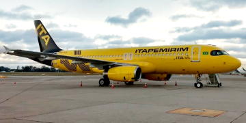 Aeronave da Itapemirim estacionada em pátio de aeroporto. Avião tem cor amarela e o nome "Itapemirim" escrito na fuselagem em preto.