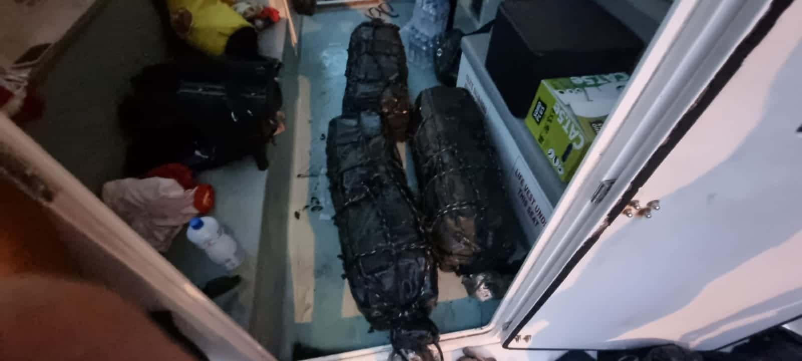 Sacos em cor escura retirados de dentro do compartimento do navio. Droga estava escondida dentro destas malas.