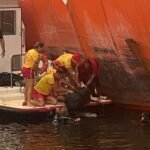 Mergulhadores, ao lado do navio, recolhem mala com cocaína de dentro d'água.