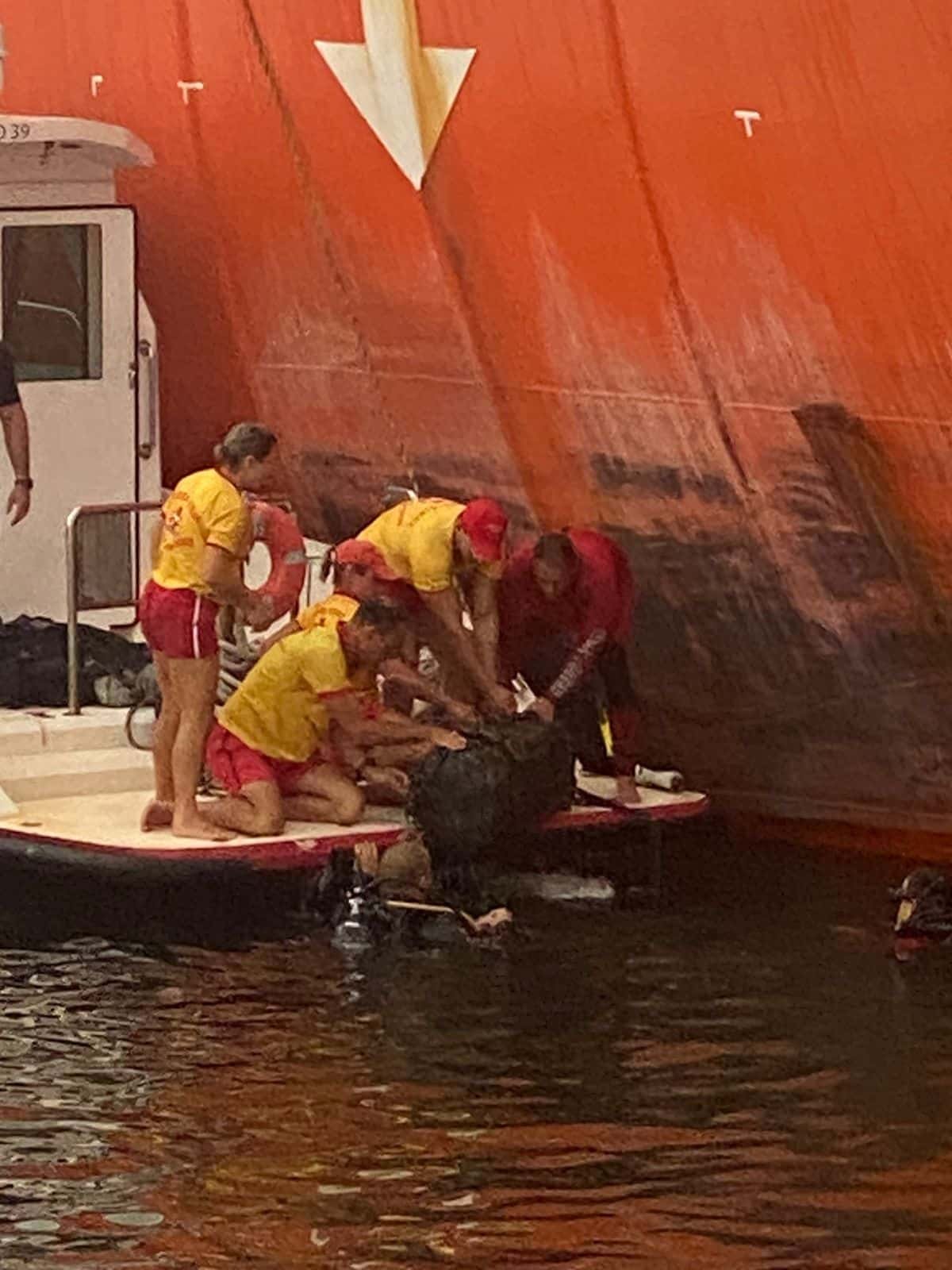 Mergulhadores, ao lado do navio, recolhem mala com cocaína de dentro d'água.