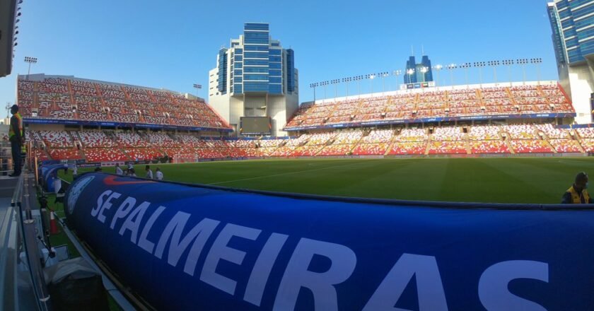 Faixa ao lado do campo mostra o nome do Palmeiras. Ao fundo, arquibancadas e o campo de futebol onde a final do mundial será disputada.