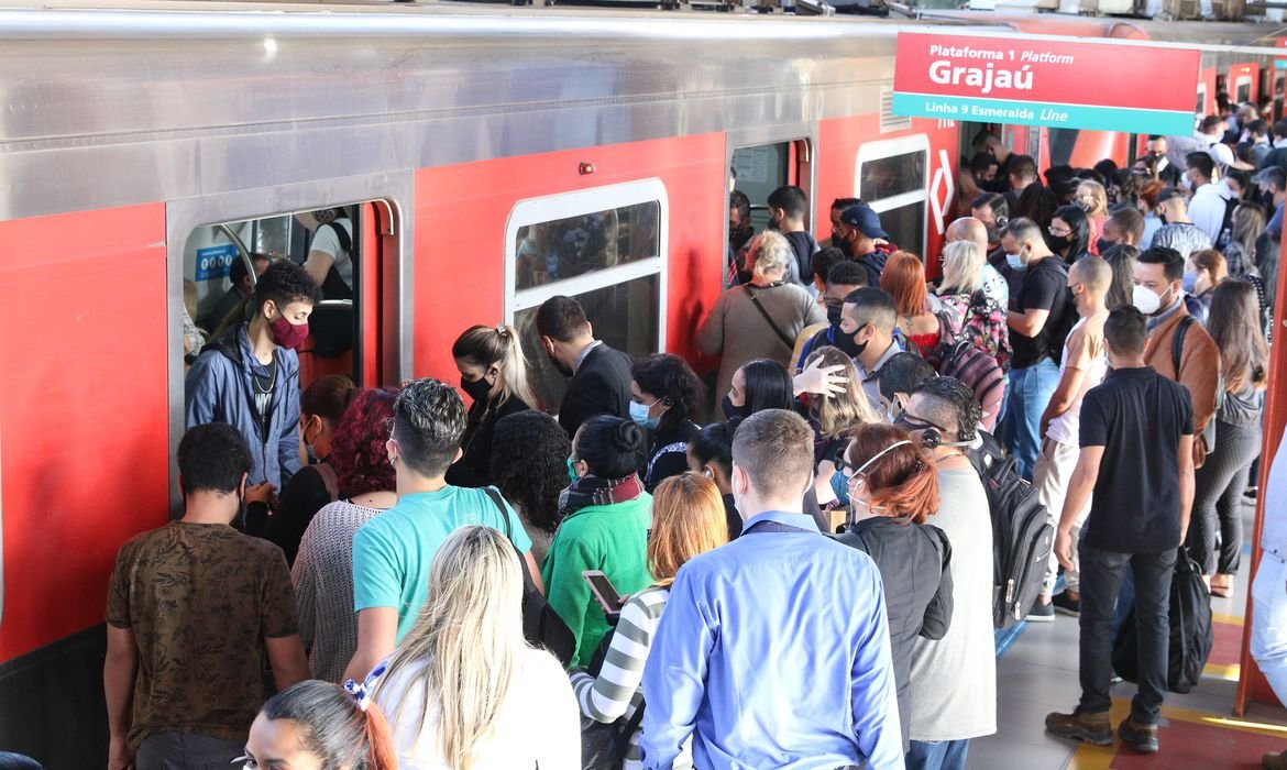 Passageiros entram e saem do trem. No alto da foto é possível ler na placa o nome da estação Grajaú.