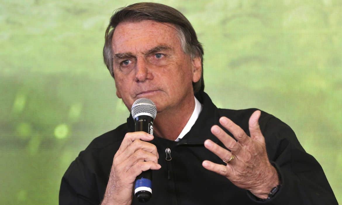 Jair Bolsonaro discursa segurando microfone com a mão direita e com a mão esquerda gesticula.