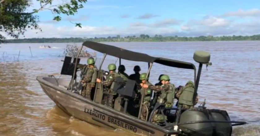 Militares em embarcação do exército navegam por rio no Amazonas.