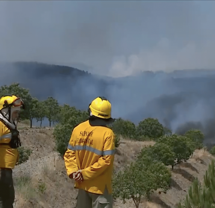 Bombeiros monitoram incêndio a partir do alto de um morro na região de Vila Real, em Portugal.