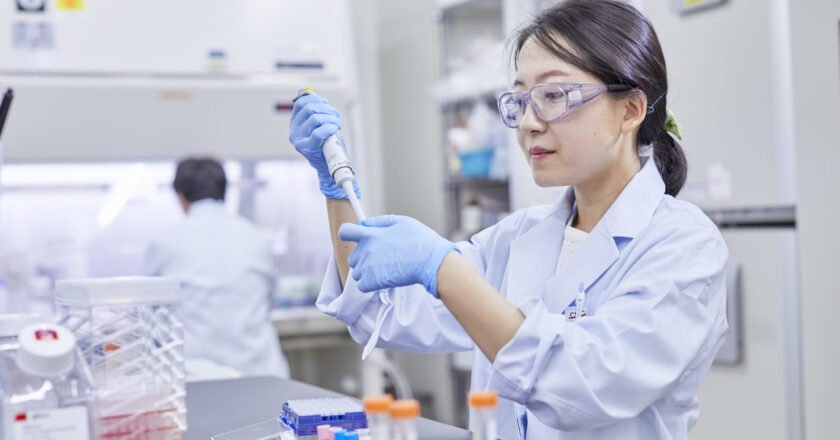 Médica geneticista da farmacêutica JCR manipula um tubo de ensaio dentro de um laboratório no Japão.