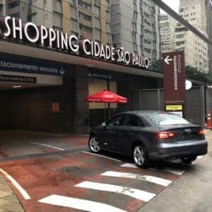 Entrada do estacionamento mostra carro entrando no prédio. No alto é possível ler o nome do Shopping Cidade de são Paulo.
