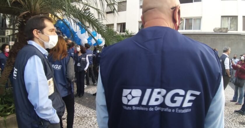 Funcionários do IBGE durante lançamento da pesquisa em São paulo. De costas para foto, um dos homens acompanha ação. Nas costas é possível ler IBGE.